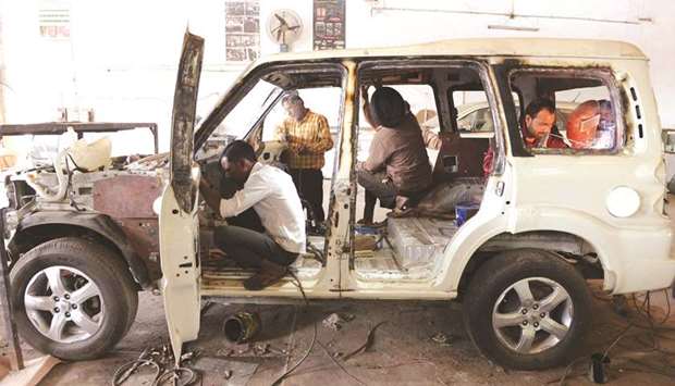 Mechanics work to make an SUV bulletproof at the Laggar Industries workshop on the outskirts of Jalandhar.