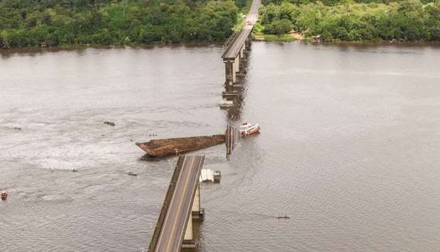 A boat approaches the damaged bridge over the Moju River in Acara, Para state, Brazil.