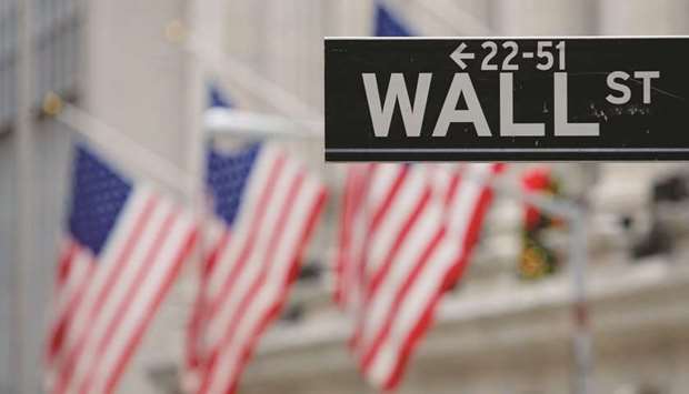 A street sign for Wall Street is seen outside the New York Stock Exchange in New York (file). Pressures on profitability u2013 particularly from rising workersu2019 wages u2013 will be in focus this quarter, as every S&P 500 sector has seen margin estimates cut for 2019.
