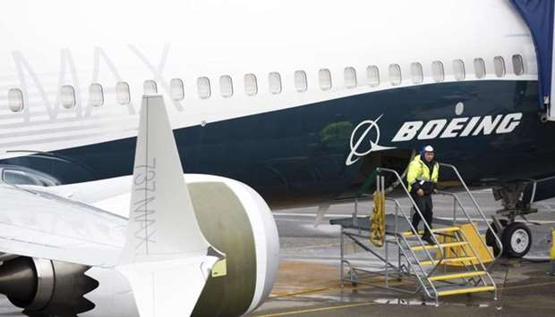 A worker is pictured next to a Boeing 737 MAX 9 airplane on the tarmac at the Boeing Renton Factory in Renton, Washington, on  In this file photo taken on March 12.
