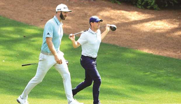 Rory McIlroy of Northern Ireland and Dustin Johnson of the United States walk on the second hole during a practice round prior to The Masters at Augusta National Golf Club in Augusta, Georgia.