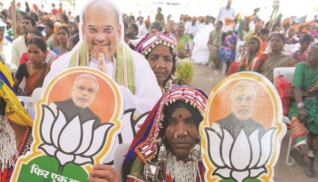 Lambadi tribal women carry pictures of Prime Minister Narendra Modi and a cutout of BJP president Amit Shah at a rally in Hyderabad yesterday.
