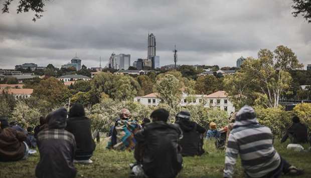 The skyline of the rich district of Sandton is seen as a group of homeless persons gather in Innesfree Park in Johannesburg, yesterday. The pandemic will have a substantial impact on food production and could lead to a food security crisis in the region.