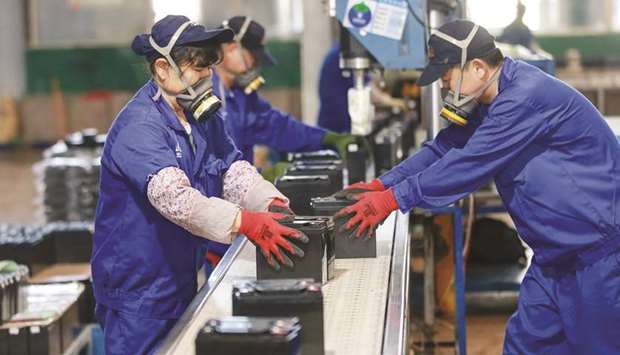 Employees working on a battery production line at a factory in Huaibei, Anhui province. Factory activity in China rebounded in March from a record low, according to official data released yesterday, returning to expansion territory while the coronavirus pandemic continues to devastate the global economy.