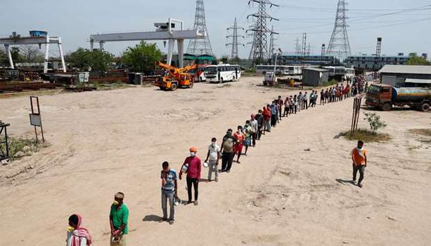 Daily wage labourers stand in a queue for free food at a construction site where activity has been halted due to 21-day nationwide lockdown to slow the spreading of the coronavirus disease, in New Delhi yesterday.