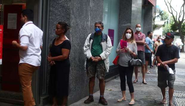 People wait in line to enter a bank during the outbreak of the coronavirus disease in the Copacabana neighbourhood in Rio de Janeiro, Brazil.
