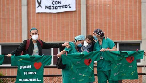 Healthcare workers confort the wife of Esteban, a male nurse that died of coronavirus at the Severo Ochoa Hospital in Leganes, near Madrid