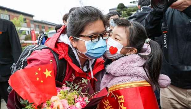 A member (L) of a medical assistance team from Huaian being welcomed by her daughter after returning home from Wuhan to help with the Covid-19 coronavirus recovery effort in Huaian in China's eastern Jiangsu province