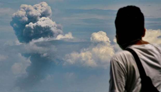 A man watches Krakatau spewing ash during an eruption, in Serang, Indonesia's Banten province