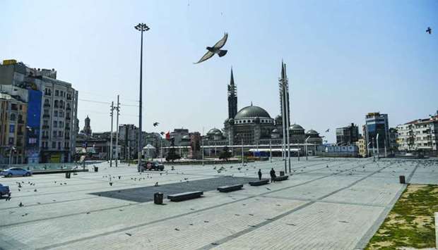 Pigeons fly over the empty Taksim square in Istanbul