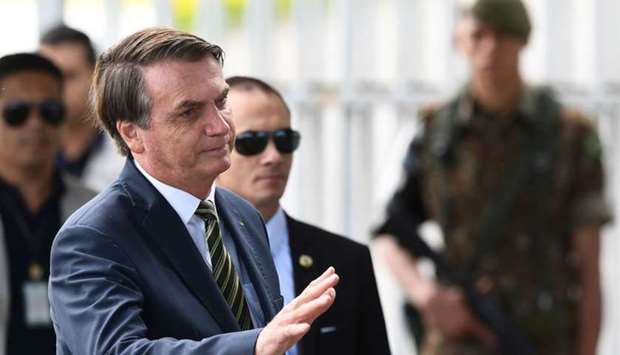 Brazilian President Jair Bolsonaro talks to supporters as he leaves Alvorada Palace in Brasilia, Brazil.
