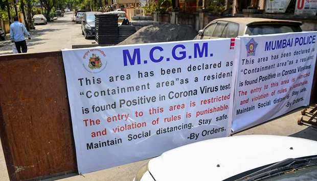 Noticeboards are pasted on barricades as they are set up to close the entrance of a residential complex in Mumbai yesterday.