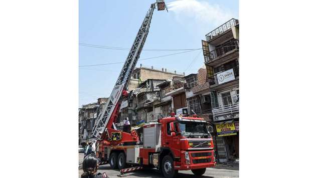 Firefighters use a crane to spray disinfectant in Ahmedabad yesterday.