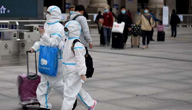 Passengers wearing hazmat suits arrive at the Hankou railway station in Wuhan, Chinau2019s central Hubei province yesterday.