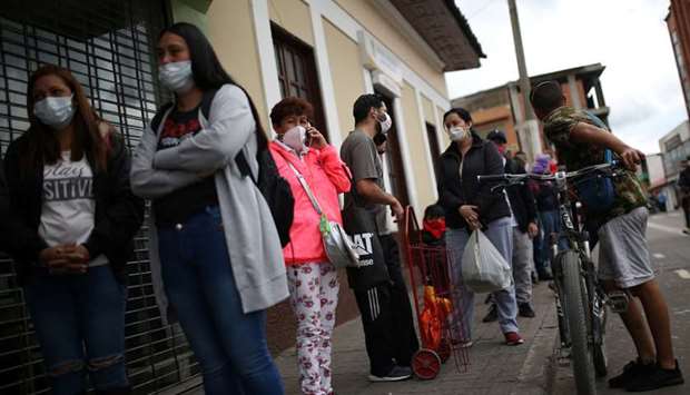 People wear face masks while queuing to enter a supermarket during the mandatory isolation decreed by the Colombian government as a preventive measure against the spread of Covid-19 in Soacha, Colombia.