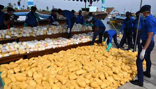 Sri Lankan Navy personnel sort out narcotics seized from a flagless cargo carrier, at a fisheries harbour near Colombo yesterday.