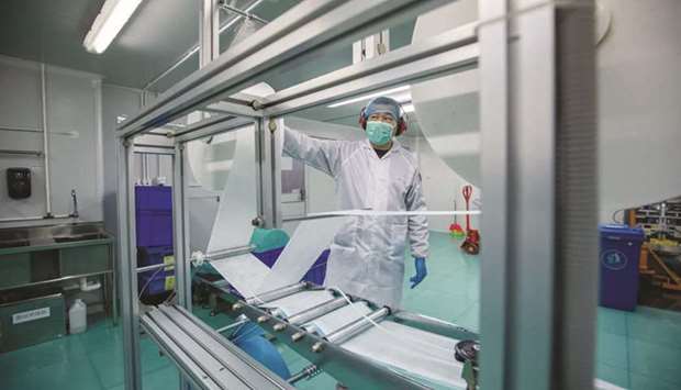 A worker operates a machine on the protective mask production line at the Mask Factory Co facility in Hong Kong.