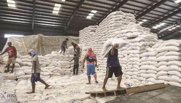 Workers carry sacks of rice inside a National Food Authority warehouse in Manila.