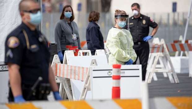 A health worker in protective gear waits to hand out self-testing kits in a parking lot of Rose Bowl Stadium during the global outbreak of the coronavirus disease (Covid-19), in Pasadena, California, US