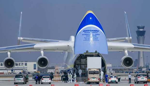 Workers in protective suits load medical supplies onto an Antonov cargo plane bound for Poland's Warsaw amid a global outbreak of the novel coronavirus disease (Covid-19), at an airport in Tianjin, China