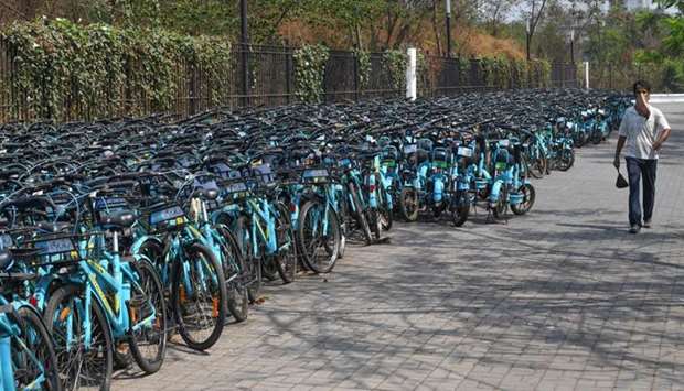 A man walks past rental bicycles stacked outside a a park during a government-imposed nationwide lockdown as a preventive measure against the spread of the Covid-19 coronavirus in Navi Mumbai