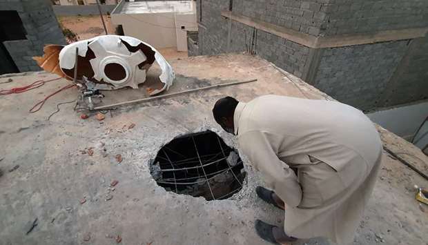 A Libyan checks the site of shelling on the residential area of Arada in the capital Tripoli, yesterday.