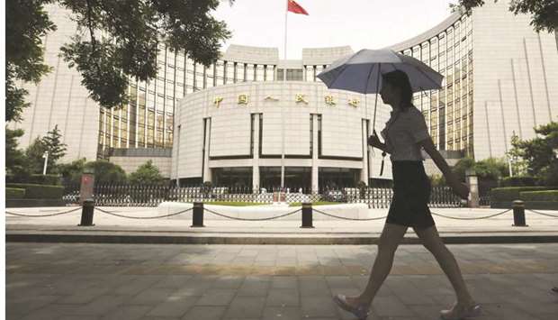 A pedestrian walks past the Peopleu2019s Bank of China headquarters in Beijing.
