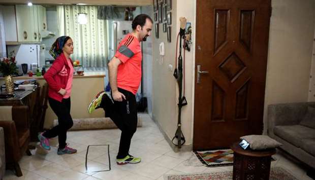 Majid and his daughter train at their home as they watch online workouts, following the outbreak of Covid-19, in Tehran.