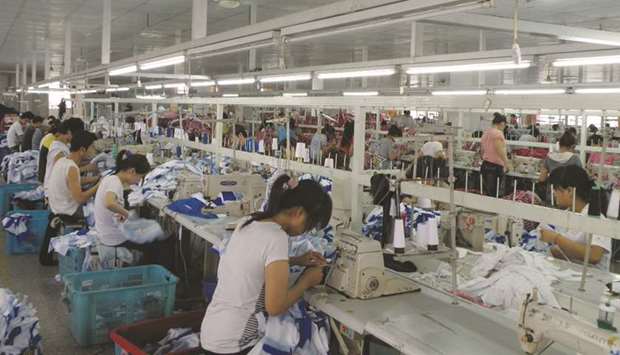 Workers make Orolay jackets at the companyu2019s factory complex in Jiaxing, Zhejiang province. Chinau2019s gross domestic product fell 6.8% in January-March year-on-year, official data showed yesterday, a slightly larger decline than the 6.5% forecast by analysts and reversing a 6% expansion in the fourth quarter of 2019.