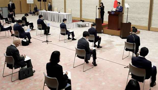 Japan's Prime Minister Shinzo Abe (top R) speaks during a press conference at the prime minister's official residence in Tokyo