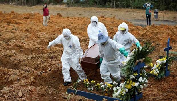 Gravediggers wearing protective clothing prepare to bury 78-year-old Lelito Jose Martins, who passed away due to the coronavirus disease (COVID-19), at the Parque Taruma cemetery in Manaus