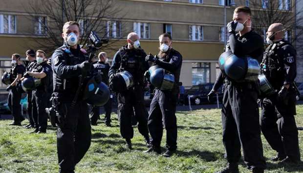 Police officers wear protective face masks during a demonstration of conspiracy theorists as other demonstrators protest against the lockdown imposed to slow the spread of the coronavirus disease, in Berlin, Germany