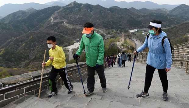 Visitors wearing face masks amid concerns of the Covid-19 coronavirus walk along the Great Wall of China in Beijing yesterday.
