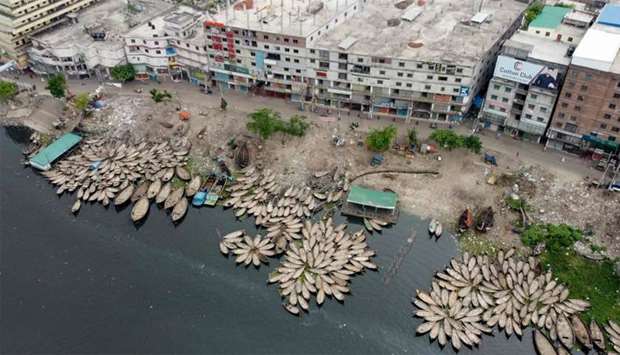 This aerial picture shows boats docking on the bank of a river during a government-imposed lockdown as a preventive measure against the COVID-19 coronavirus in Dhaka