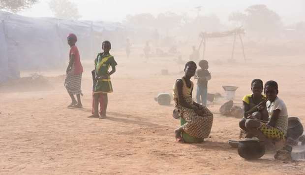 Displaced people, who fled from attacks of armed militants in Roffenega, are engulfed in dust as they sit at the camp built by the German Ngo HELP in Pissila, Burkina Faso January 24, 2020
