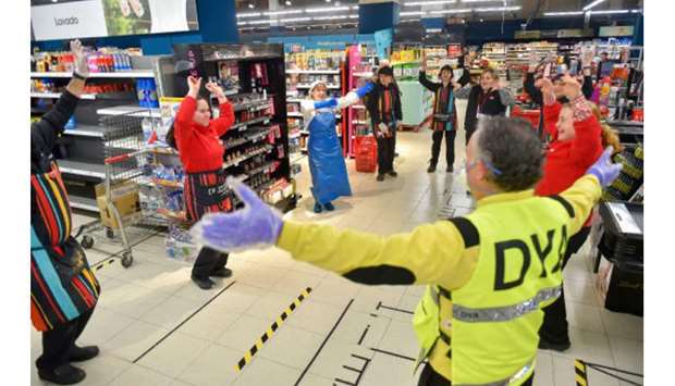 Volunteers of the nonprofit organisation DYA, who buy food for people who can not leave their homes, dance with workers of a supermarket in the Basque Spanish city of San Sebastian yesterday during a national lock-down to prevent the spread of the coronavirus.