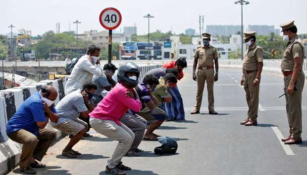 Police look on as people hold their ears while doing sit-ups as a punishment for breaking a lockdown, in Chennai, yesterday.