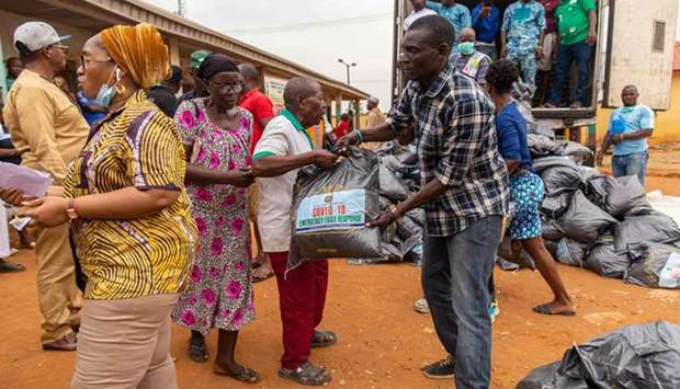 Lagos State officials hand out the food relief bags to people of the Agbado and Oke-Odo LCDA community, yesterday.
