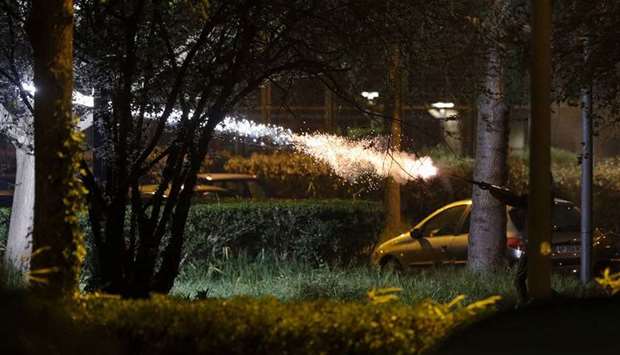A man fires fireworks during clashes in Villeneuve-la-Garenne, in the northern suburbs of Paris, late on Monday.