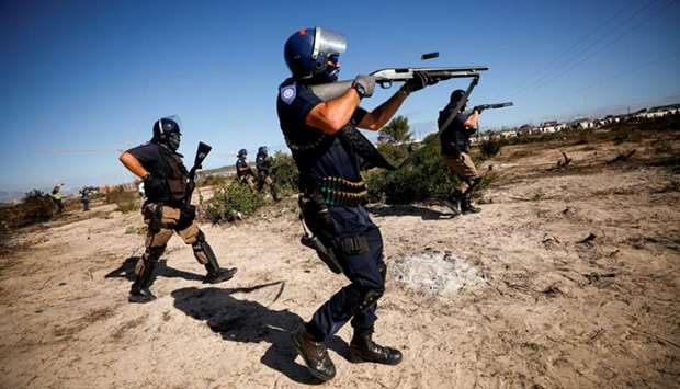 Police fire shotguns and tear gas as they attempt to disperse Khayelitsha township residents trying to erect shacks on open ground during a nationwide lockdown aimed at limiting the spread of the coronavirus disease (Covid-19), in Cape Town, South Africa yesterday.