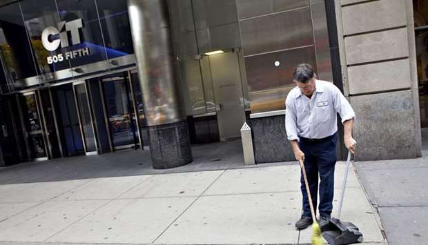 A building maintenance worker sweeps the sidewalk outside the former CIT Group Inc headquarters in New York (file).