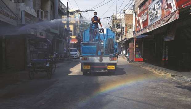 A municipal worker sprays disinfectant in a market area during an extended nationwide lockdown, in New Delhi yesterday.