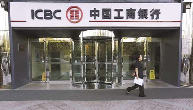 A woman walks past an Industrial & Commercial Bank of China branch in Beijing. Chinese banks, led by ICBC, are bracing for an unprecedented drop in profits this year as they grapple with the fallout of Covid-19.