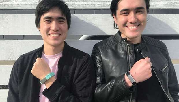 Entrepreneurs Matthew Toles and Joseph Toles, co-founders of the company Slightly Robot, show smartbands, the Immutouch, which buzz when the weareru2019s hand goes near their face, to prevent spreading the coronavirus disease (Covid-19), in Seattle, US, in this handout picture taken on March 31.
