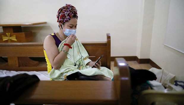 A hospital worker wearing a protective face mask video calls a relative while at a funeral chapel that temporarily shelters health workers from a nearby hospital taking in coronavirus disease patients, in Makati City, Metro Manila, Philippines.