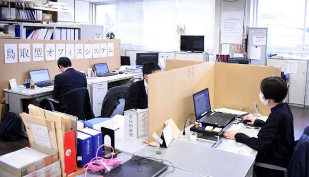 Office employees use cardboard partitions to separate their desks amid concerns over the coronavirus, at the prefectural government office in Tottori, western Japan.