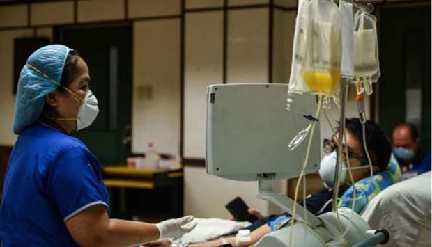 A nurse (left) checks on a patient who has recovered from the Covid-19 coronavirus at a hospital in Manila, yesterday.