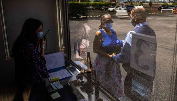 Clerk Recorder Erika Patronas (left) officiates a wedding ceremony at a parking lot in Anaheim, California. The County of Orange Clerk Recorder employees implemented a variety of social distancing techniques to safely issue licenses and marry couples during the novel coronavirus pandemic.