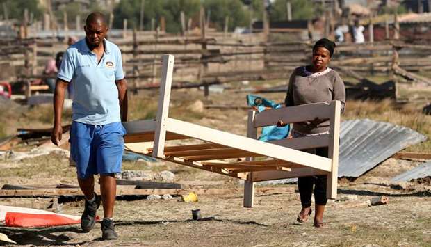 People remove possessions after law enforcement officials moved in to demolish shacks after Khayelitsha township residents attempted to occupy vacant land during a nationwide lockdown aimed at limiting the spread of Covid-19 in Cape Town, yesterday.