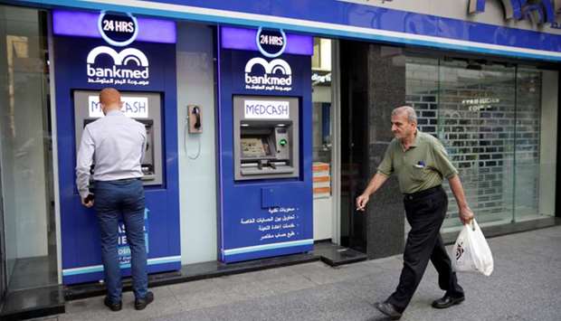 A man walks past a closed bank office in Beirut, Lebanon (file). Lebanon is struggling to cope with dwindling foreign-currency reserves and double-digit inflation amid its worst financial crisis in decades.